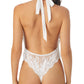 A lady wearing white LACE ALLURE HALTER BODYSUIT