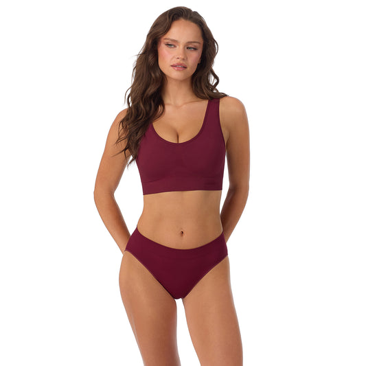A Lady Wearing Seamless Comfort Wireless Back Smoother - Currant posing with a front view standing pose
