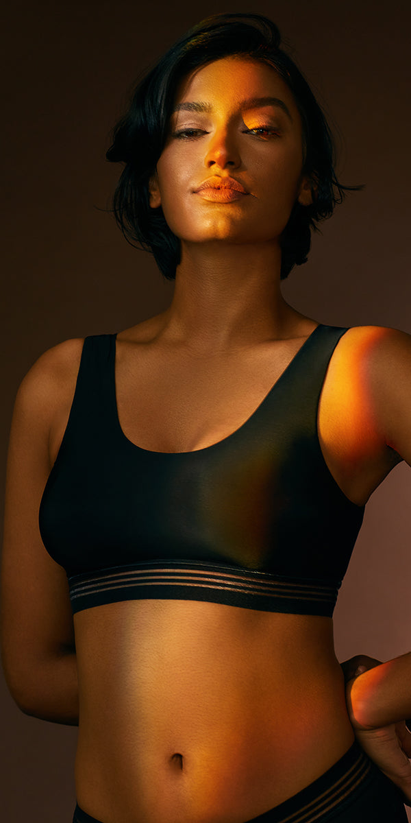 A lady wearing a black second skin bralette.